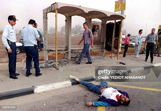 Gaza Palestinian Ali Talib El-Emmawi lies dead on the road in front of the soldiers hitchiking station near Ashdod, Israel, where he opened fire on...