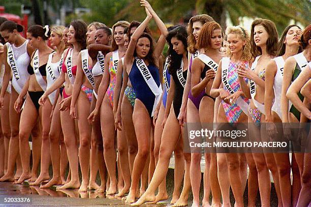 Miss Colombia, Carolina Gomez , claps her hands as contestants for the Miss Universe pageant pose in their swimsuits 05 May 1994 during a taping to...