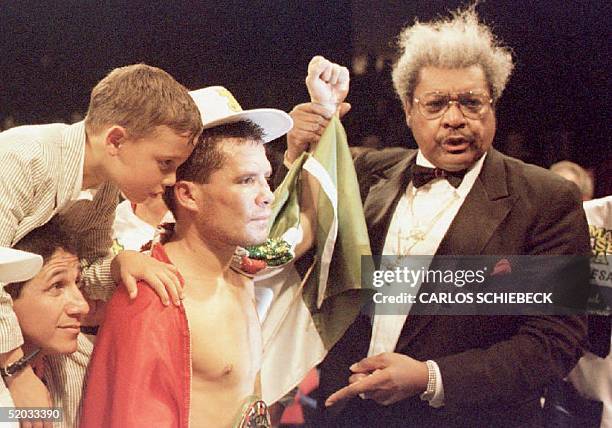 Julio Cesar Chavez of Mexico is surrounded by his son Julio Jr and promoter Don King after judges awarded Chavez a victory in his WBC Super...