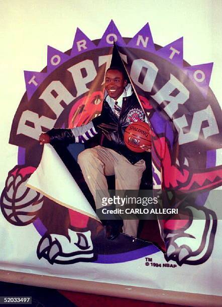 Isaiah Thomas, who retired earlier this month after 13 seasons with the Detroit Pistons, bursts through a Toronto Raptors logo at a press conference...