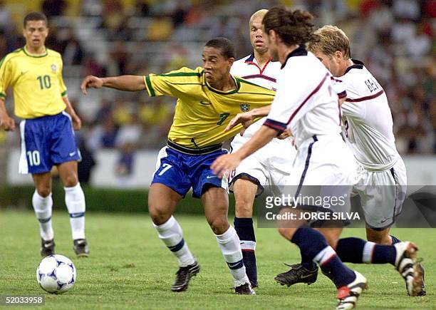 Ronaldinho of Brazil is held by US players during their match 28 July 1999 in Guadalajara. Ronaldinho, goleador de la seleccion brasilera, es...