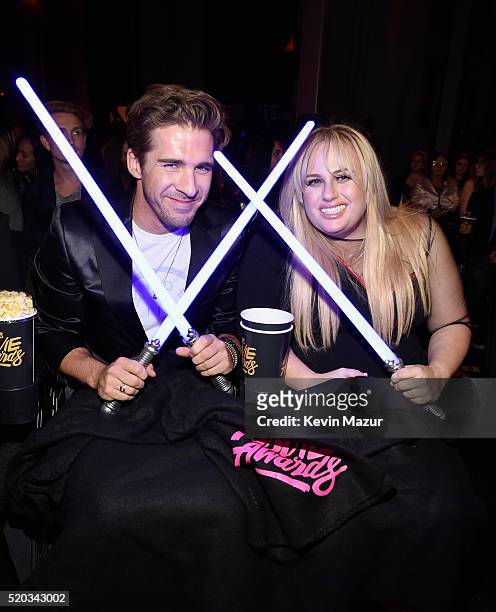 Actor Hugh Sheridan and actress Rebel Wilson display 'Star Wars: The Force Awakens' lightsabers during the 2016 MTV Movie Awards at Warner Bros....