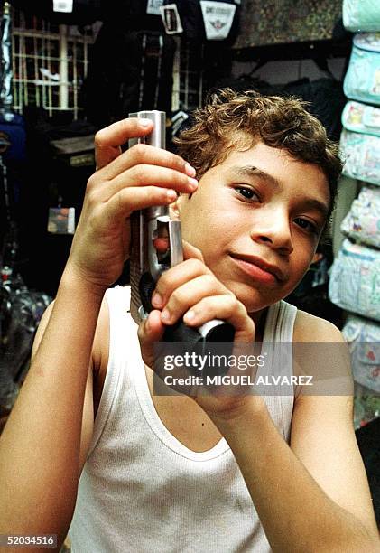 Elvis Peralta, age 12, handles a toy gun, that he bought for two dollars in a local market September 22 1999. Elvis Peralta, de 12 anos, manipula una...