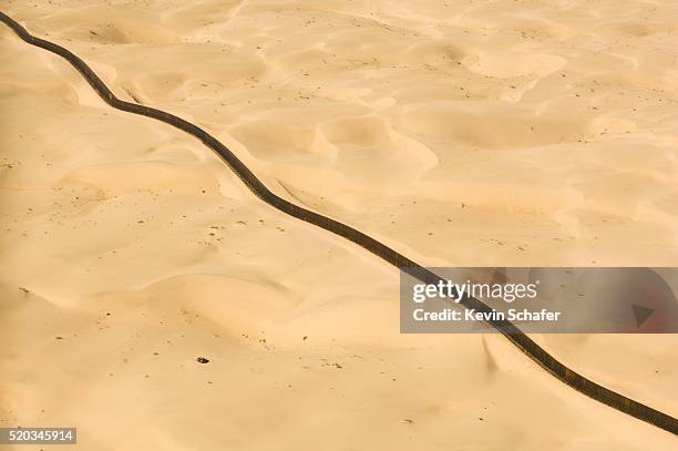 us-mexico border fence in imperial dunes - yuma stock pictures, royalty-free photos & images