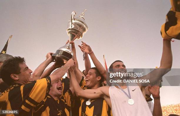 The team players of Penarol Pablo Bengoechea , Antonio Pacheco , Dario Rodriguez and Marcelo de los Santos celebrate their victory in the Centenario...