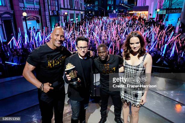 Writer/director J.J. Abrams and actress Daisy Ridley accept the Movie of the Year award for 'Star Wars: The Force Awakens' with co-hosts Dwayne...