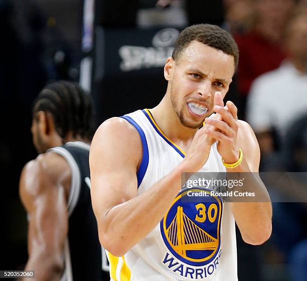 Stephen Curry of the Golden State Warriors applauds his team's effort in game against the San Antonio Spurs at AT&T Center on April 10, 2016 in San...