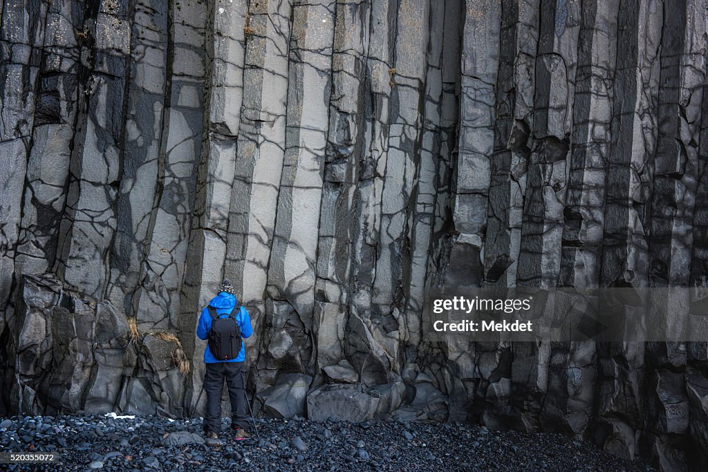 A man with volcanic Basalt cliff at Reynisfjara, Iceland