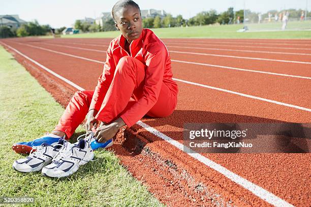 track and field athlete putting on shoes - tiersport stock pictures, royalty-free photos & images