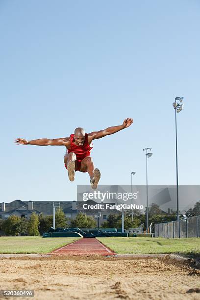 sauteur en longueur dans les airs - long jump photos et images de collection