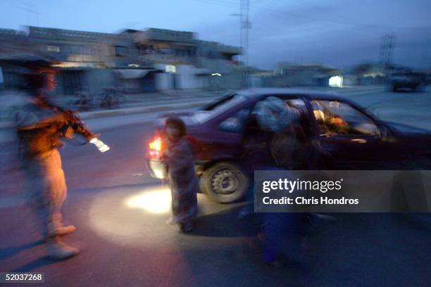 Soldiers with the 25th Infantry Division approach a car immediately after they fired on the vehicle January 18, 2005 in Tal Afar, Iraq. The troops...