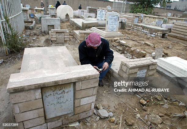 An Iraqi man prays at a grave at the Imam Ghazali cemetery in Baghdad 20 January 2005, for the start of Eid al-Adha. Muslims all over the world will...