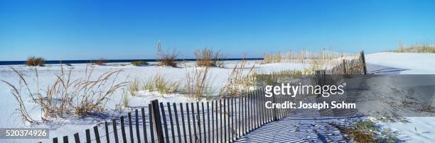 fence along white sand beach - beach panoramic stock pictures, royalty-free photos & images