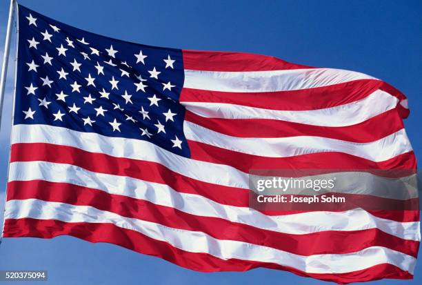 american flag blowing in the wind - amerikanische flagge stock-fotos und bilder