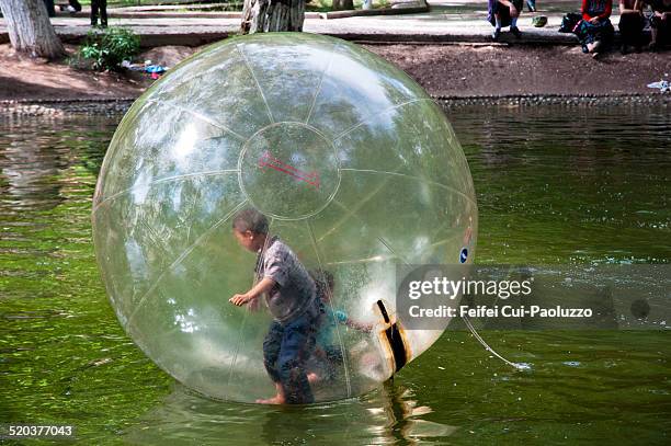 children paying in a in inflatableb ball on the water in an amusement park at kashgar, xinjiang province, china - water walking ball stock pictures, royalty-free photos & images