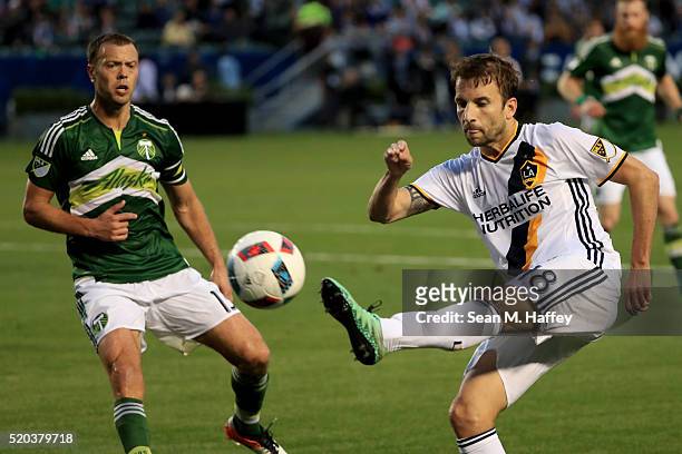 Mike Magee of Los Angeles Galaxy shoots on goal against the Los Angeles Angels of Anaheim Jack Jewsbury of the Portland Timbers defend during the...