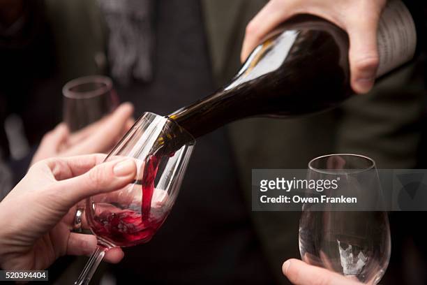 pouring red wine at a beaujolais nouveau festival - red wine stockfoto's en -beelden
