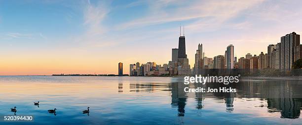 the chicago skyline over lake michigan at dusk - michiganmeer stockfoto's en -beelden