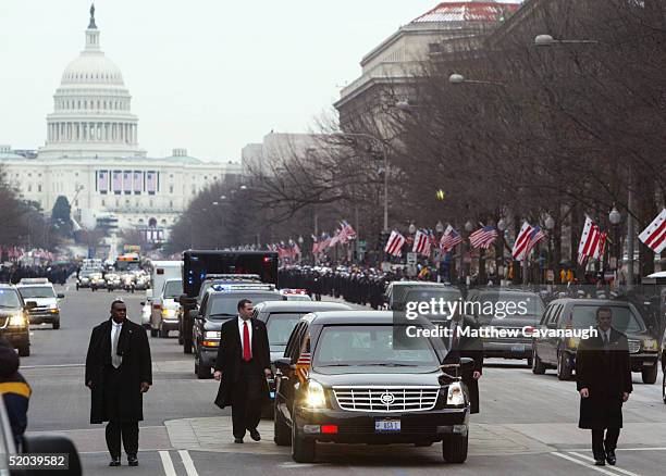 Secret Service agents walk along side as U.S. President George W. Bush rides in the Inaugural parade on Pennsylvania Avenue January 20, 2005 in...