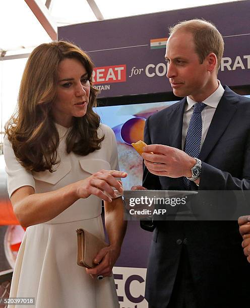 Britain's Prince William, Duke of Cambridgeeats a "Dosa" a traditional Indian food as his wife Catherine, Duchess of Cambridge looks onduring a Young...