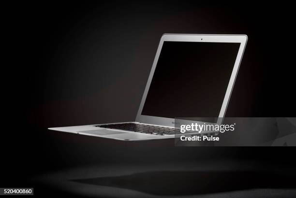 floating macbook air. - floating laptop stock pictures, royalty-free photos & images