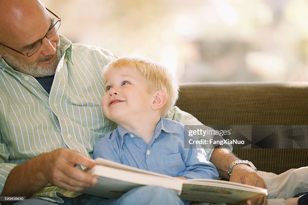 Großvater liest mit seinem Enkel