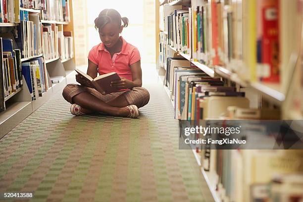 fille lisant à la bibliothèque - diagonal bookshelf photos et images de collection