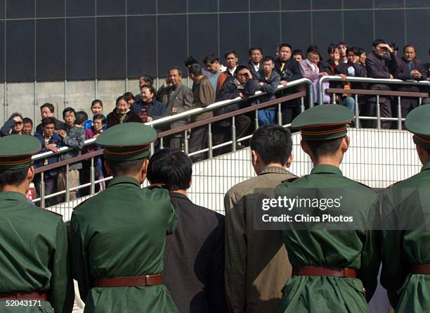 Police parade convicted criminals, who illegally sold train tickets, during a public sentence at a railway station January 21, 2005 in Shenzhen of...