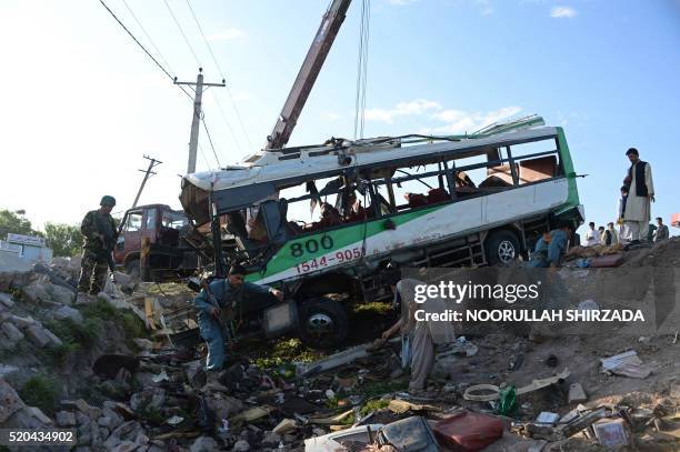 Afghan security forces inspect the site of a suicide attack on a bus carrying Afghan army recruits in Jalalabad on April 11, 2016. - At least 12...