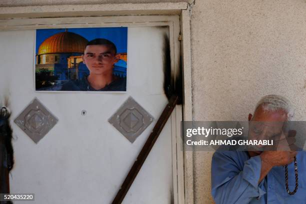 Relative of Abed Dawiyat sheds tears as he sits at the entrance of the family house after Israeli forces sealed off the building in the Palestinian...