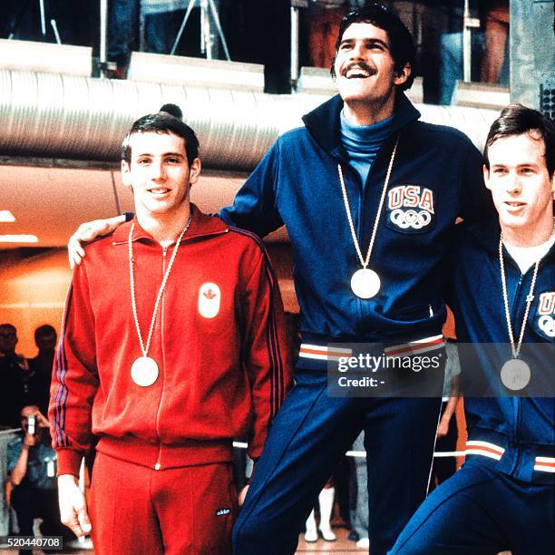 American swimmer Mark Spitz smiles on the podium after winning the gold medal in the 100m butterfly in front of Canadian Bruce Robertson and...
