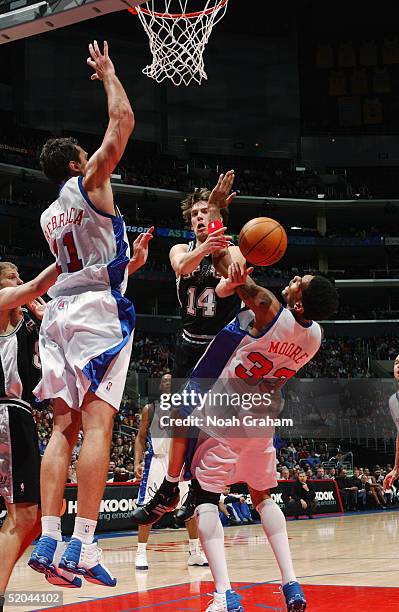 Beno Udrih of the San Antonio Spurs passes the ball in the lane against Zeljko Rebraca and Mikki Moore of the Los Angeles Clippers on December 31,...