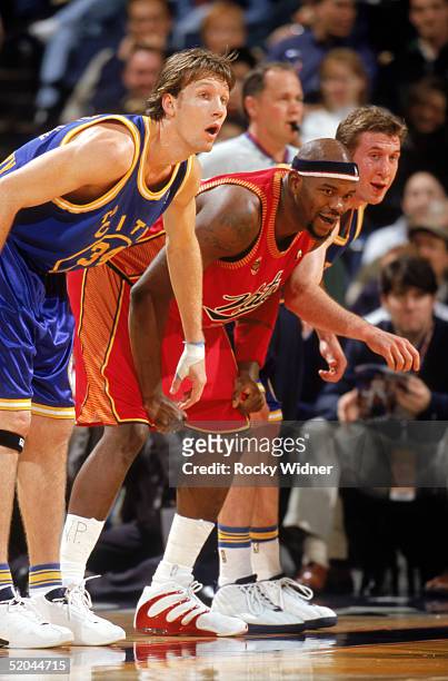 Marc Jackson of the Philadelphia 76ers stands in position between Mike Dunleavy Jr. #34 and Troy Murphy of the Golden State Warriors during a game at...