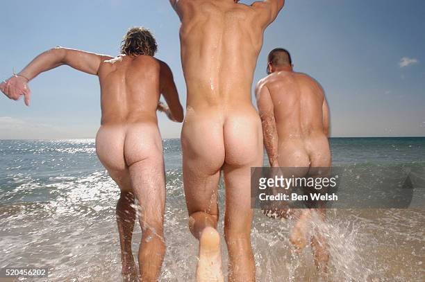 three naked men running into the sea - man skinny dipping stock pictures, royalty-free photos & images
