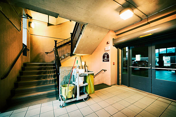 cleaning cart in front of parking garage stairway - nettoyage de parking photos et images de collection