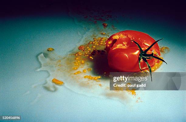 seeds and juice running out of broken cherry tomato - schiacciato foto e immagini stock