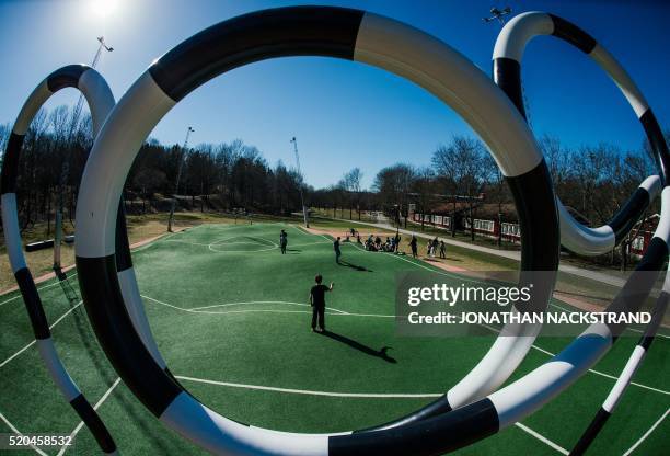 Children play on the "Puckelboll" pitch in Skaerholmen, south-west of Stockholm, on April 11, 2016. The 'Puckelboll' pitch is an artwork designed by...