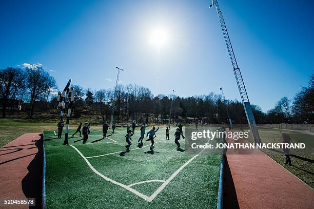 Children play on the "Puckelboll" pitch in Skaerholmen, south-west of Stockholm, on April 11, 2016. The 'Puckelboll' pitch is an artwork designed by...