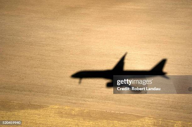 shadow of landing plane - airplane shadow stock pictures, royalty-free photos & images