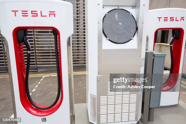 a tesla electric vehicle recharging station at the crystal building - brand name stock pictures, royalty-free photos & images