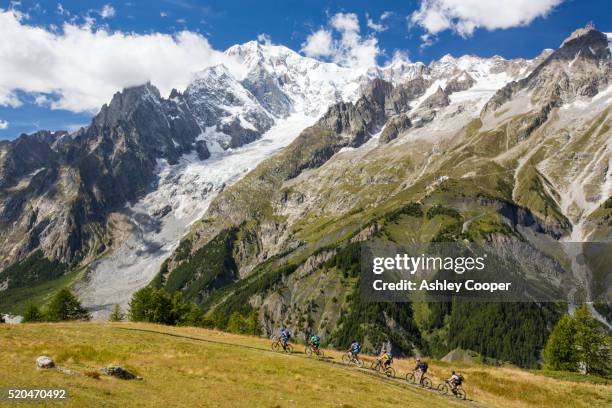 the rapidly receding brenva glacier in the mont blanc range, italy, with cyclists - brenva glacier stock pictures, royalty-free photos & images