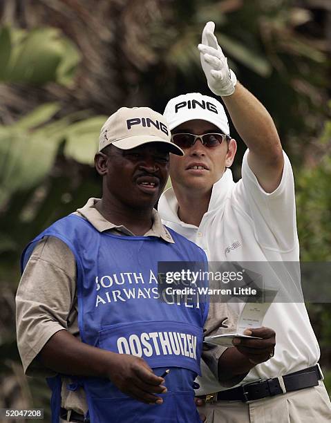 Louis Oosthuizen of South Africa points out the line of the fifth hole to his caddy during the third round of the South African Airways Open at...