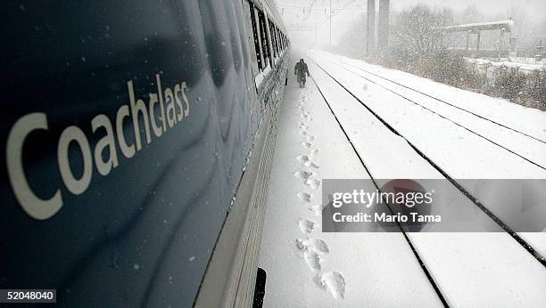 An Amtrak worker walks along the tracks checking for debris beneath the train after it stopped January 22, 2005 near Wilmington, Delaware....