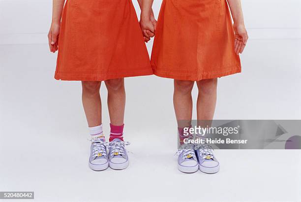 twin sisters holding hands - girl socks - fotografias e filmes do acervo