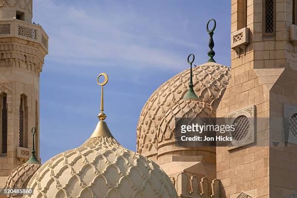 ornate domes of the jumeirah mosque in dubai - mosque stock-fotos und bilder