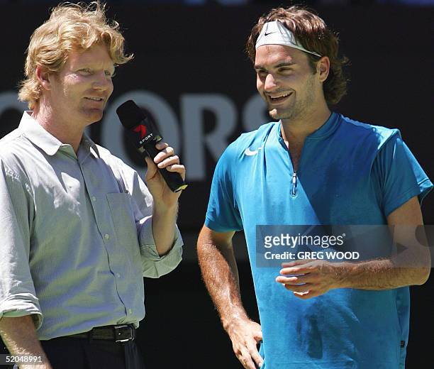Top seed Roger Federer of Switzerland shares a laugh with former US player and present television commentator, Jim Courier , during the post match...