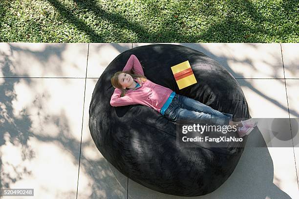 mädchen entspannt mit einem buch - bean bag stock-fotos und bilder