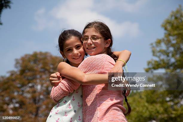 young sisters embracing - fraternal twin stock pictures, royalty-free photos & images