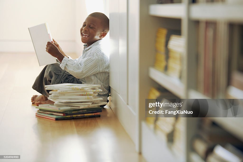 Young boy laughs at a storybook