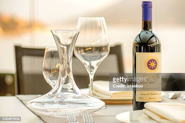 romantic dinner at the sunset. sassicaia wine served - bordeaux bottle stock pictures, royalty-free photos & images